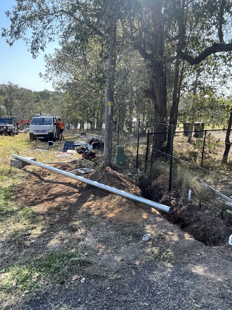The new galvanised private pole on the ground beside the trench before it went up