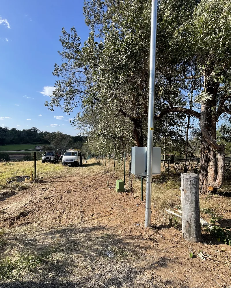 The finished pole and meter box, with the trench backfilled and the ground made good