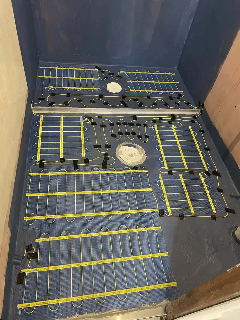 During: electric underfloor heating laid out across the waterproofed floor before tiling