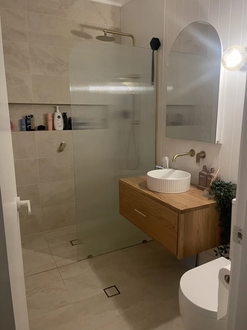 The finished room from the doorway, showing the vanity and the shower screen