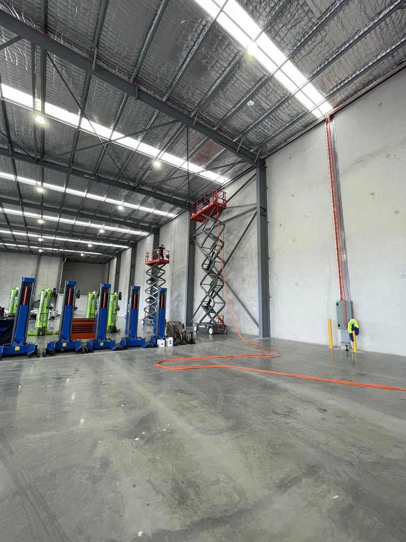 The warehouse during the fit-out, with the scissor lift up and the first battens in