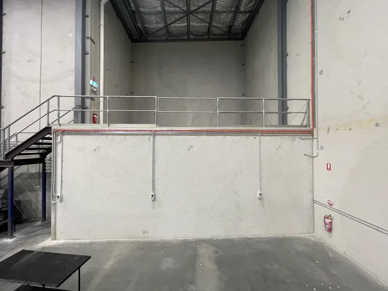 Conduit and outlets run along the mezzanine wall