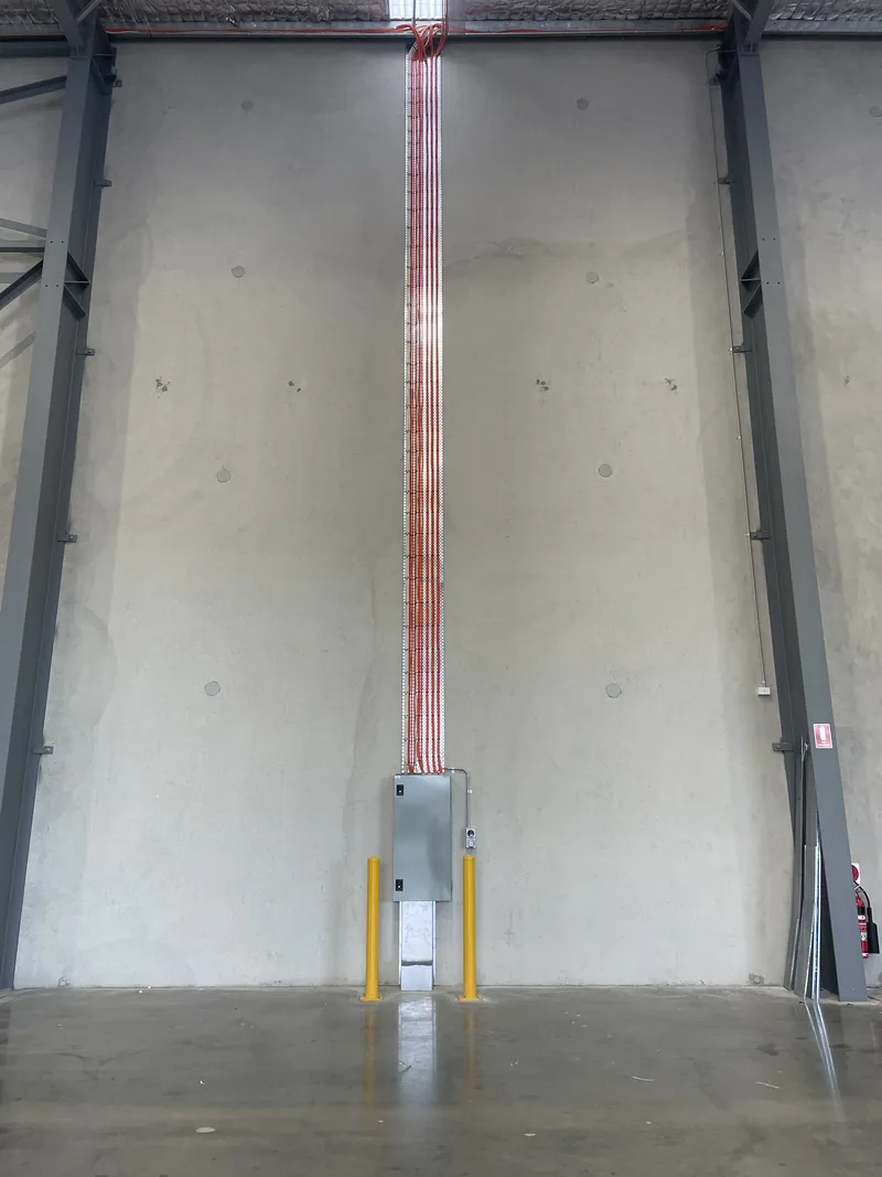 The new distribution board at the base of the wall, with the run carried up to the roof