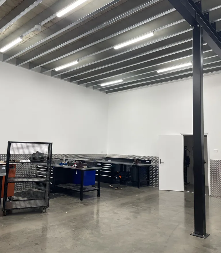 The finished workshop at Smithfield, with benches and shelving under new LED batten lighting
